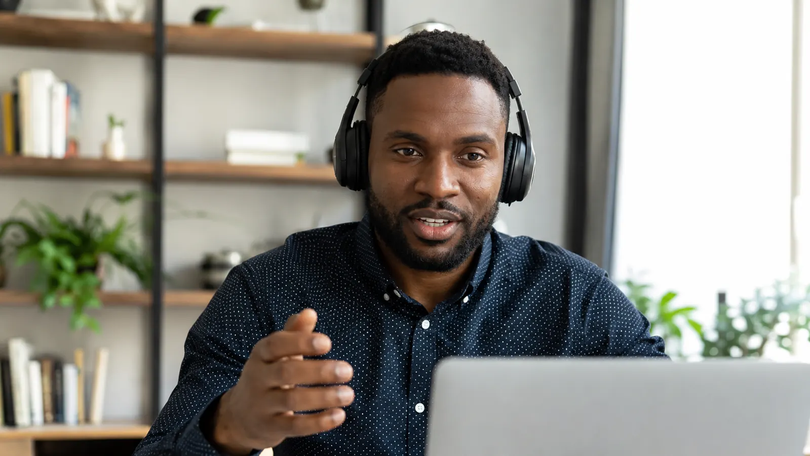 Entrepreneur on a video call, headphones on, professional home office background